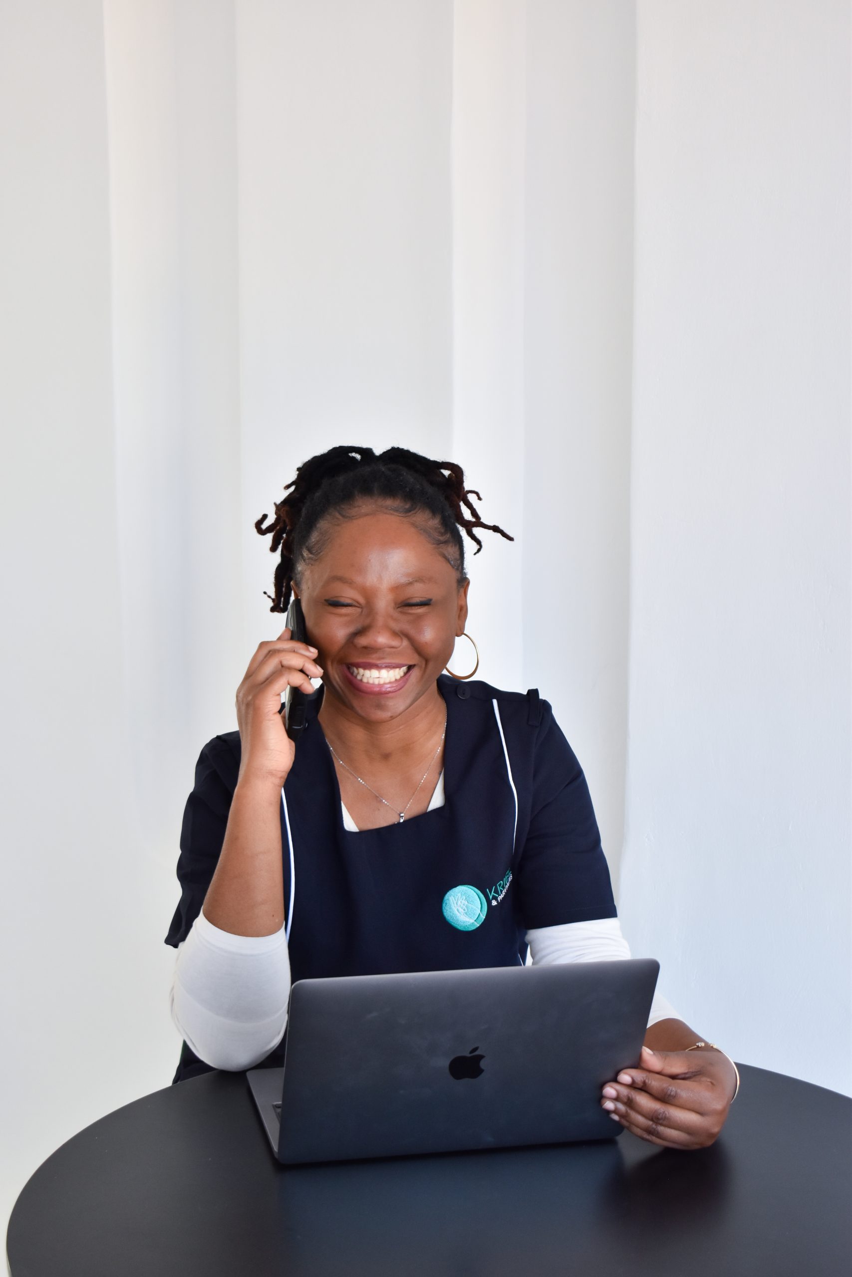 A smiling Kriel Care coordinator speaking on the phone