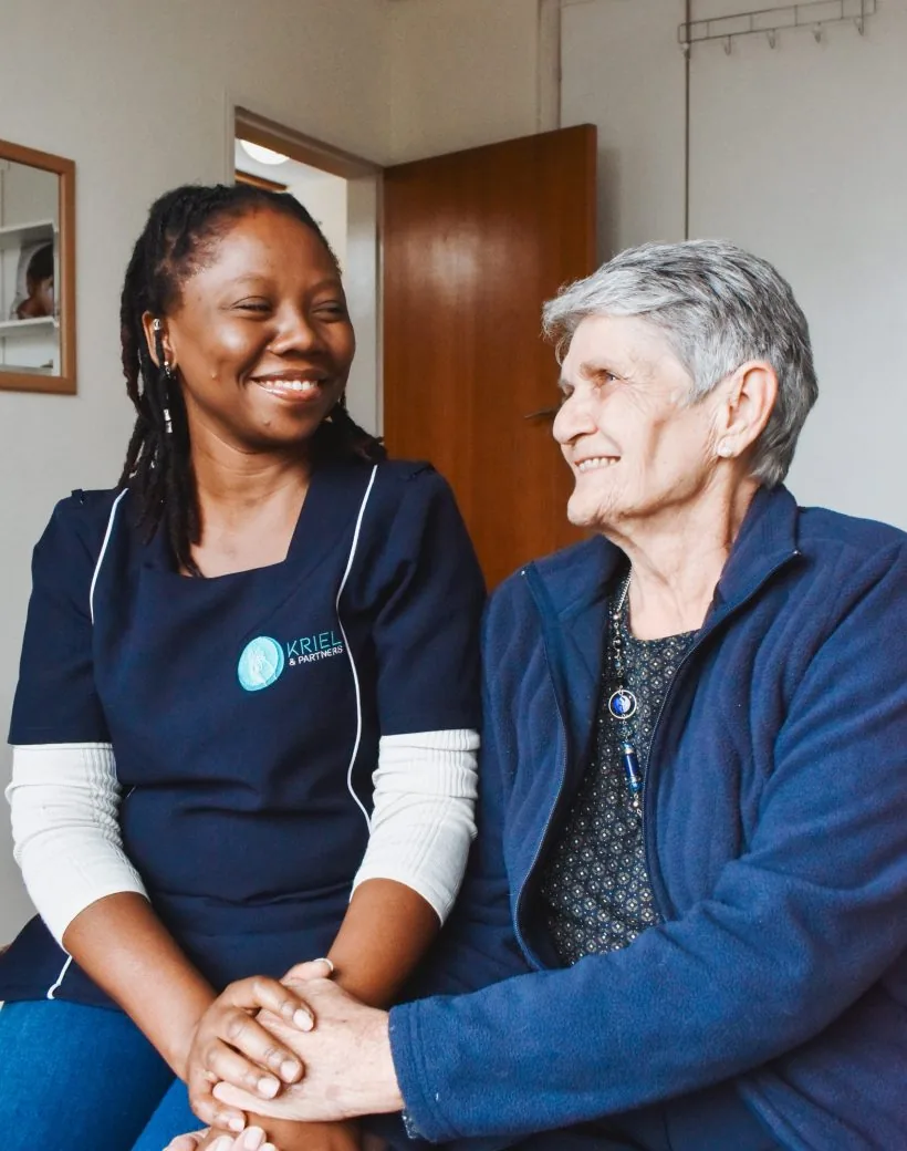 A Kriel caregiver and an older woman sharing a warm moment at home