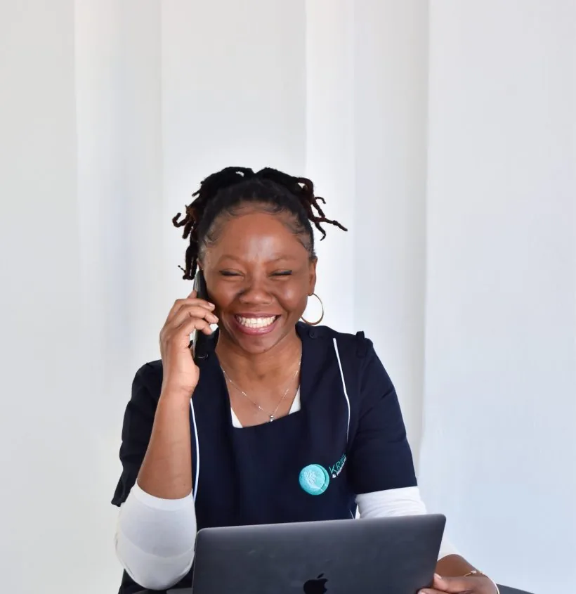 A smiling Kriel care team member speaking on the phone