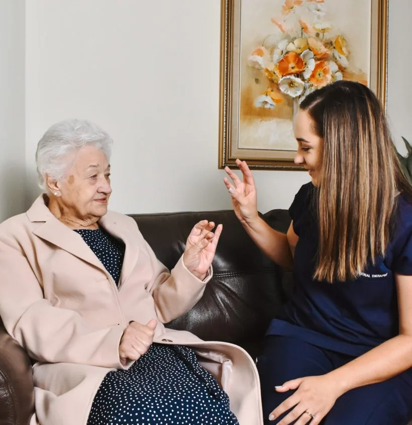A care professional supporting an older woman during an activity
